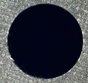 Hole drilled in composite laminate, without splintering or delamination